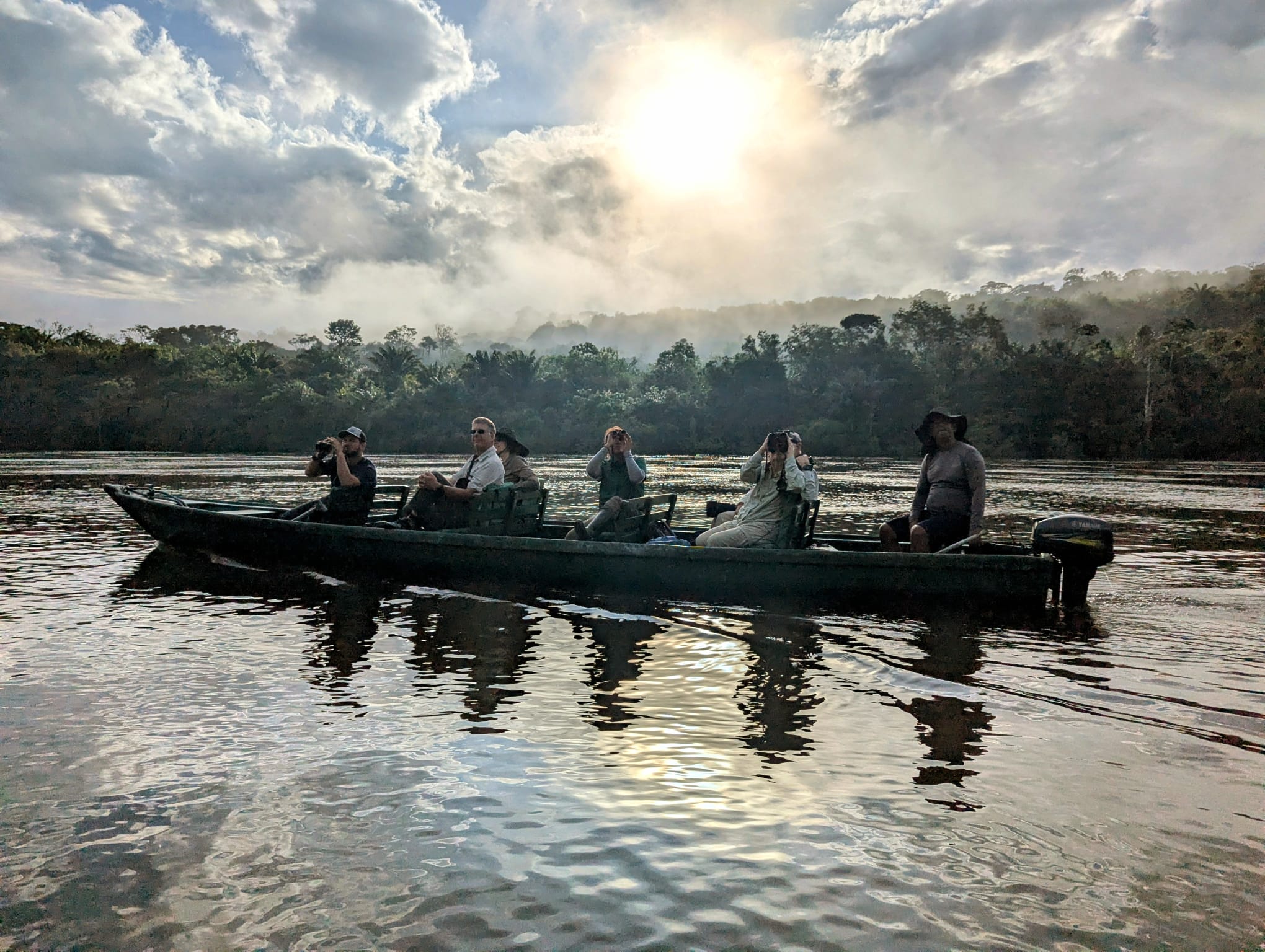 Guests birdwatching from a canoe at dawn on the Amazon